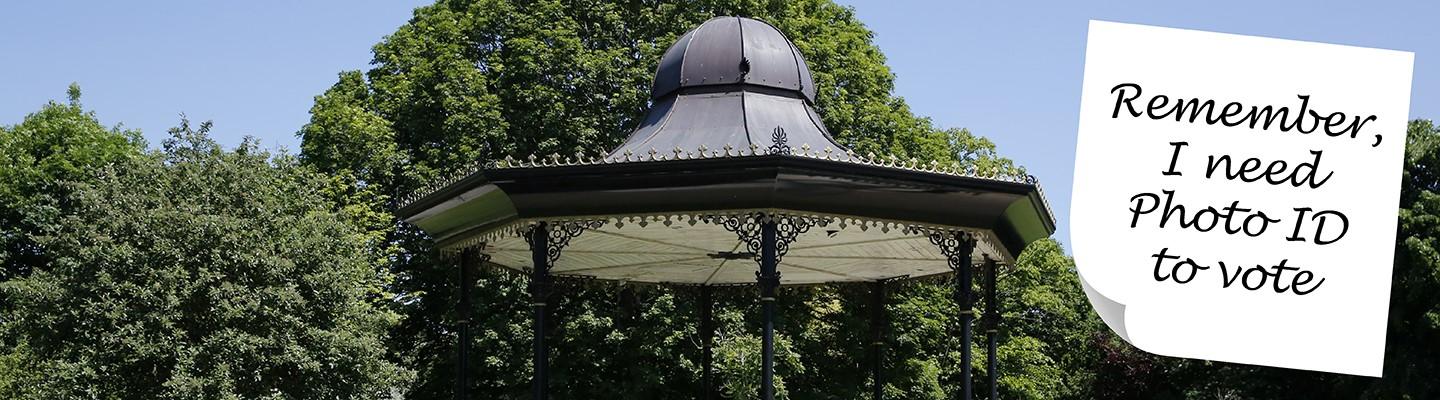 Central Park bandstand with post-it note reading &#039;remember, I need photo ID to vote&#039;